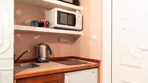 Cocina compacta equipada con microondas, hervidor y lavavajillas.