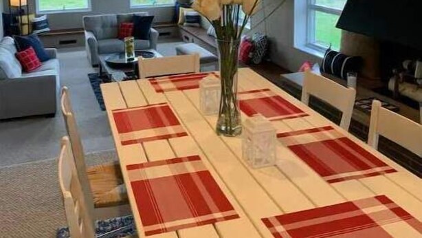 Un salon spacieux avec un coin repas, de grandes fenêtres et une cheminée.