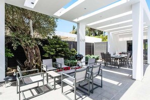 Relax in a shaded outdoor space with a covered patio, perfect for dining or socializing.
