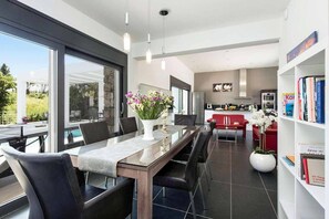 Enjoy a comfortable living area with a glass-top table, black chairs, and a cozy sofa.