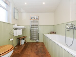 A bathroom with a wooden floor, a white sink, a toilet, a bathtub, and a shower. - Lowen Cottage (Boscastle)