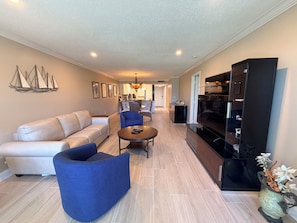 A modern living room with a sofa, blue armchair, and a coffee table.