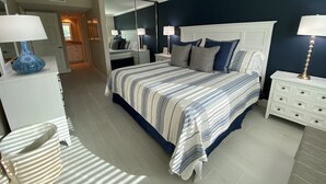 A bedroom with a bed, nightstands, a dresser, and a mirror. - Lovely Beach front 2Bd/2Bath Condo (Sarasota)