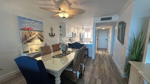 A spacious dining area with a large table, chairs, and a ceiling fan. - Enjoy beautiful sunset views (Sarasota)