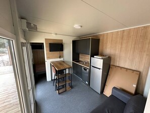 Enjoy cooking in this well-equipped kitchenette with a refrigerator, oven, and sink, perfect for preparing meals.