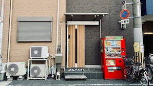 Ein modernes Gebäude mit einer Holztür, einem Automaten und einem Fahrrad vor der Tür.