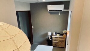Ein gemütlicher Wohnraum mit einem kleinen weißen Tisch, einer Lampe und einem Holzschrank.