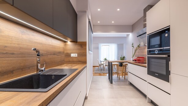 A modern kitchen with a wooden countertop, stainless steel sink, and built-in appliances. - The HostMaster Cosmopolitan Downtown Scent (Αθήνα)