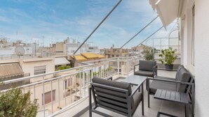 A balcony with a view of the cityscape, featuring a table and two chairs. - The HostMaster Cosmopolitan Downtown Scent (Αθήνα)