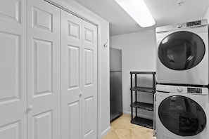 A laundry room with a washing machine, dryer, and a refrigerator.