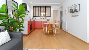 A compact living space with a kitchenette, a dining area, and a seating area with a sofa and a coffee table.
