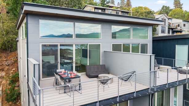 A modern two-story house with large windows, a balcony with outdoor seating, and a view of the mountains. - NEW LISTING... Magnificent NEW Townhome, overlooking dt Hood River, garage (Hood River)