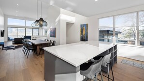 A modern kitchen with a large island, dining area, and large windows offering views of the city. - NEW LISTING... Magnificent NEW Townhome, overlooking dt Hood River, garage (Hood River)