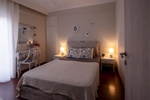 Relax in a cozy retreat with a large bed, bedside table, and comfortable chair.