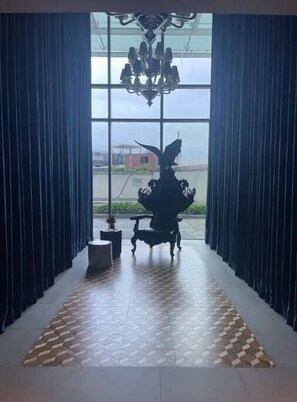 Enjoy the city view from the large window, featuring a patterned floor and a stylish chandelier.