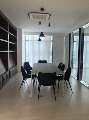 Enjoy meals in this dining area with a large window, shelving unit, and comfortable seating for six.