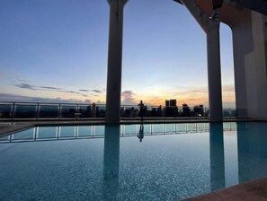 Enjoy breathtaking city views from our rooftop pool, surrounded by columns and a glass barrier.