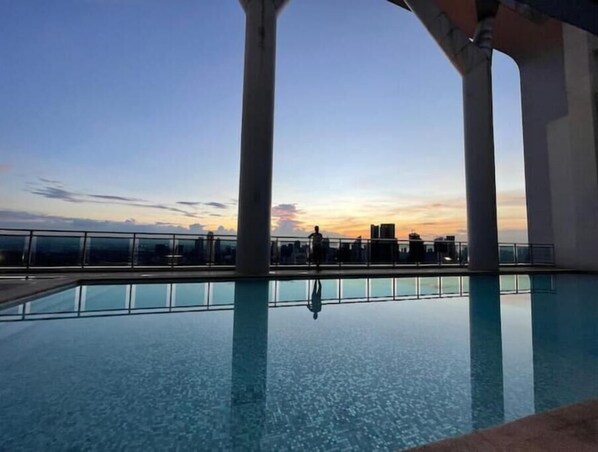 Enjoy breathtaking city views from our rooftop pool, surrounded by columns and a glass barrier.