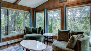 A cozy room with a large window, a green sofa, a round table, and a sign that reads "Imagine". - Otter Creek Manor - Oversized 3bd, 1.5 Ba. 3 acres, creek access. (Eau Claire)