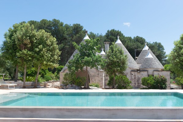 A swimming pool with stone buildings in the background.