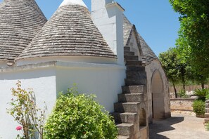 A building with conical roofs and a stone staircase leading to an entrance.