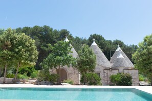 A pool area with stone buildings and trees.