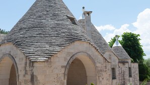 Un edificio de piedra con techo cónico y arcos.