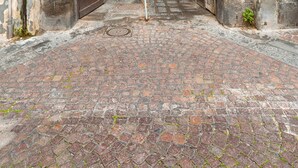 Ein gebogener Eingang zu einem Gebäude mit einem Kopfsteinpflasterweg, der hineinführt.