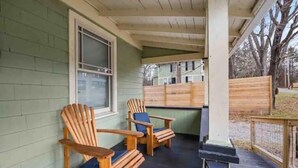 A covered porch with two Adirondack chairs and a wooden fence. - Cozy, private and modern Cottage (Hudson)