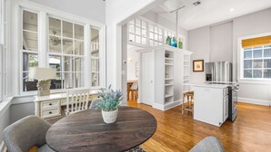 A spacious dining area with a round table, grey upholstered chairs, and a potted plant. - Pet Friendly, 150 Yards to Pool, 1 Min to the Beach, Shopping and Dining (Santa Rosa Beach)