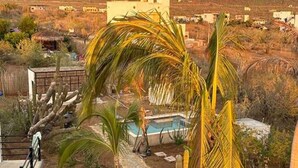A residential area with a pool, palm trees, and a mountainous backdrop. - Condo#2-5Min Walk to Beach/Surf-Sleeps2-KingSuite (Los Cerritos)