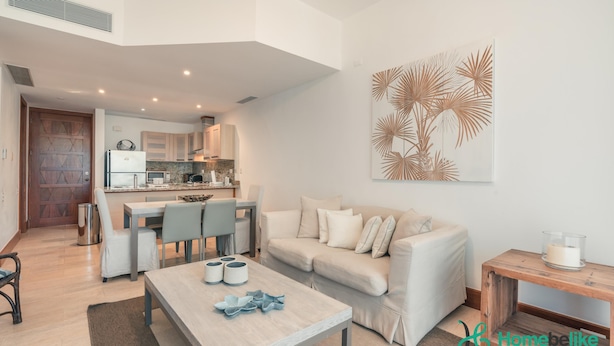 Een moderne woonkamer met een bank, salontafel en een eethoek.