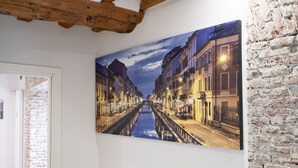 A corridor with a large painting of a canal and buildings. - Milano Suite Home - Your home in Milan! (Milano)