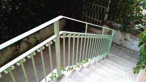 Una escalera con barandilla de metal blanco y peldaños.
