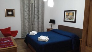 2 habitaciones, escritorio y tabla de planchar con plancha