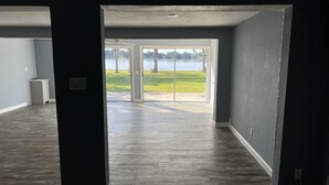 An open doorway leading to a room with a view of a lake and trees.