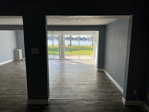 An open doorway leading to a room with a view of a lake and trees.