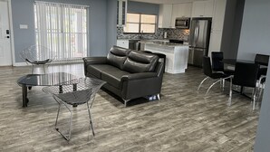 A modern kitchen with white cabinets, stainless steel appliances, and a central island.