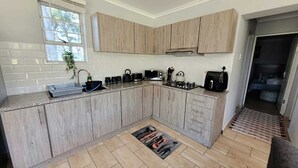 Una cocina moderna con armarios de madera clara, una estufa a gas y un horno empotrado.