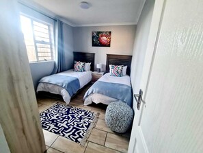 2 habitaciones, escritorio y tabla de planchar con plancha