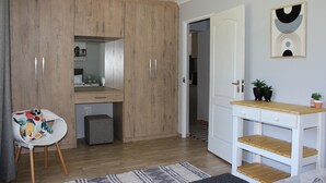 Una cocina moderna con armarios de madera, encimera blanca y un lavamanos pequeño.