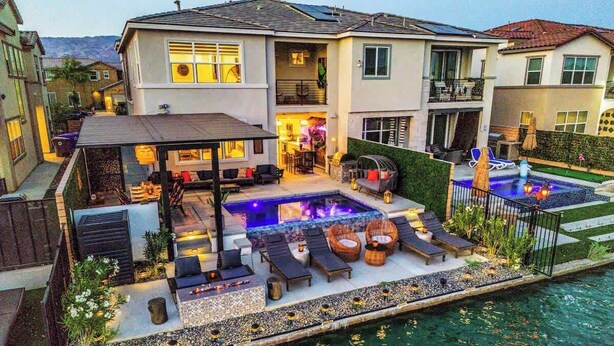 A residential property with a swimming pool, outdoor seating, and a covered patio. - Bali Hai Villa on the Lake (Indio)