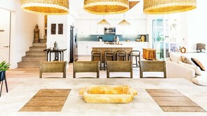 A modern interior with a dining area, kitchen, and staircase. - Bali Hai Villa on the Lake (Indio)