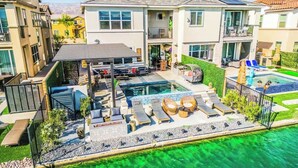 A residential property with a swimming pool, outdoor seating, and a covered patio. - Bali Hai Villa on the Lake (Indio)