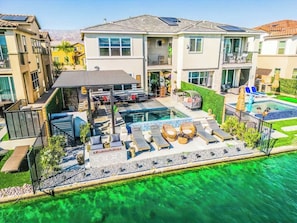 Ein Wohnhaus mit Schwimmbad, Sitzgelegenheiten im Freien und einer überdachten Terrasse.