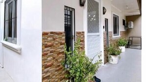 Un edificio con fachada blanca, detalles de piedra y plantas en macetas.