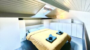 Ein kleines Schlafzimmer mit Etagenbett, Schreibtisch und Fenster mit Blick.