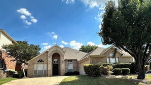 A two-story house with a front entrance, a garage, and a driveway.