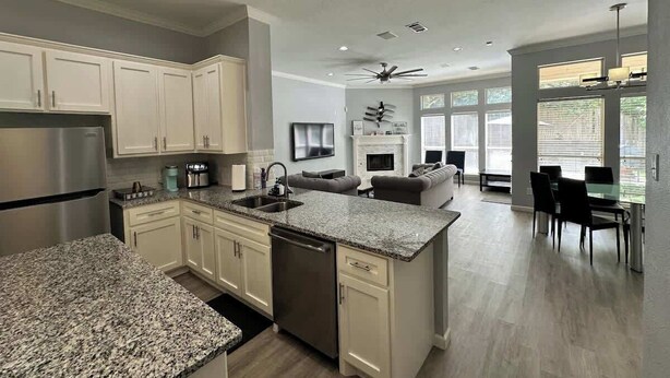 A modern kitchen with granite countertops, stainless steel appliances, and a central island.