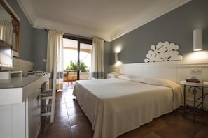 A hotel room with a bed, a desk, a chair, a small table, and a view of the outdoors. - Tranquil Lantana Resort 1 Bedroom Room Apartment Sleeps 5 (Pula)